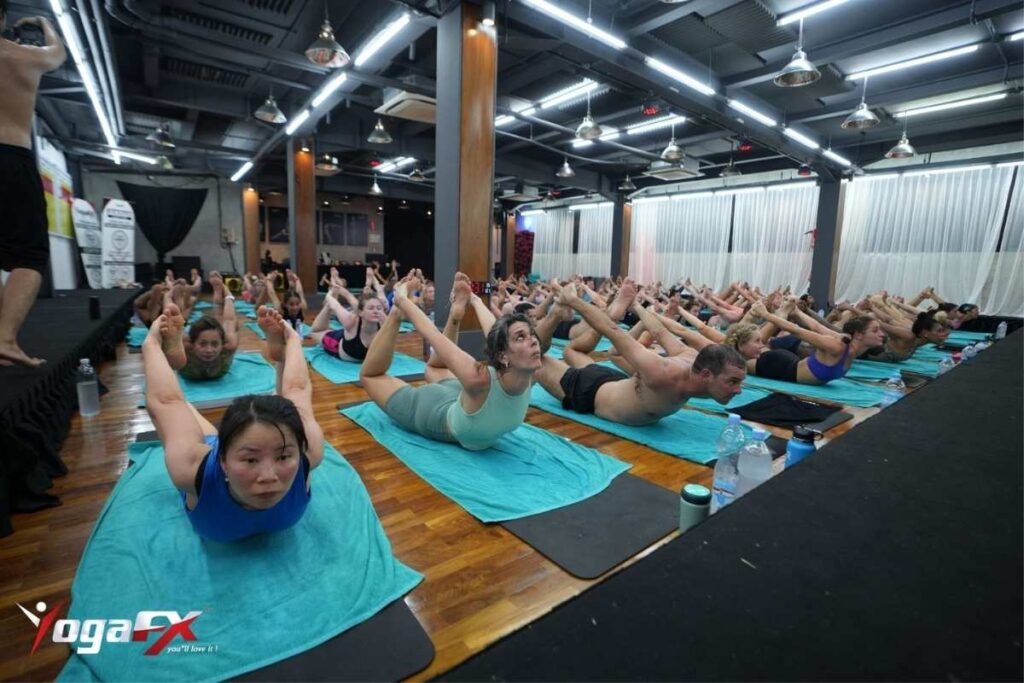 Interior of the heated Bikram yoga studio room at Bikram Yoga FX Bali, showing the mirrored wall and floor markers used for the 26-posture practice.