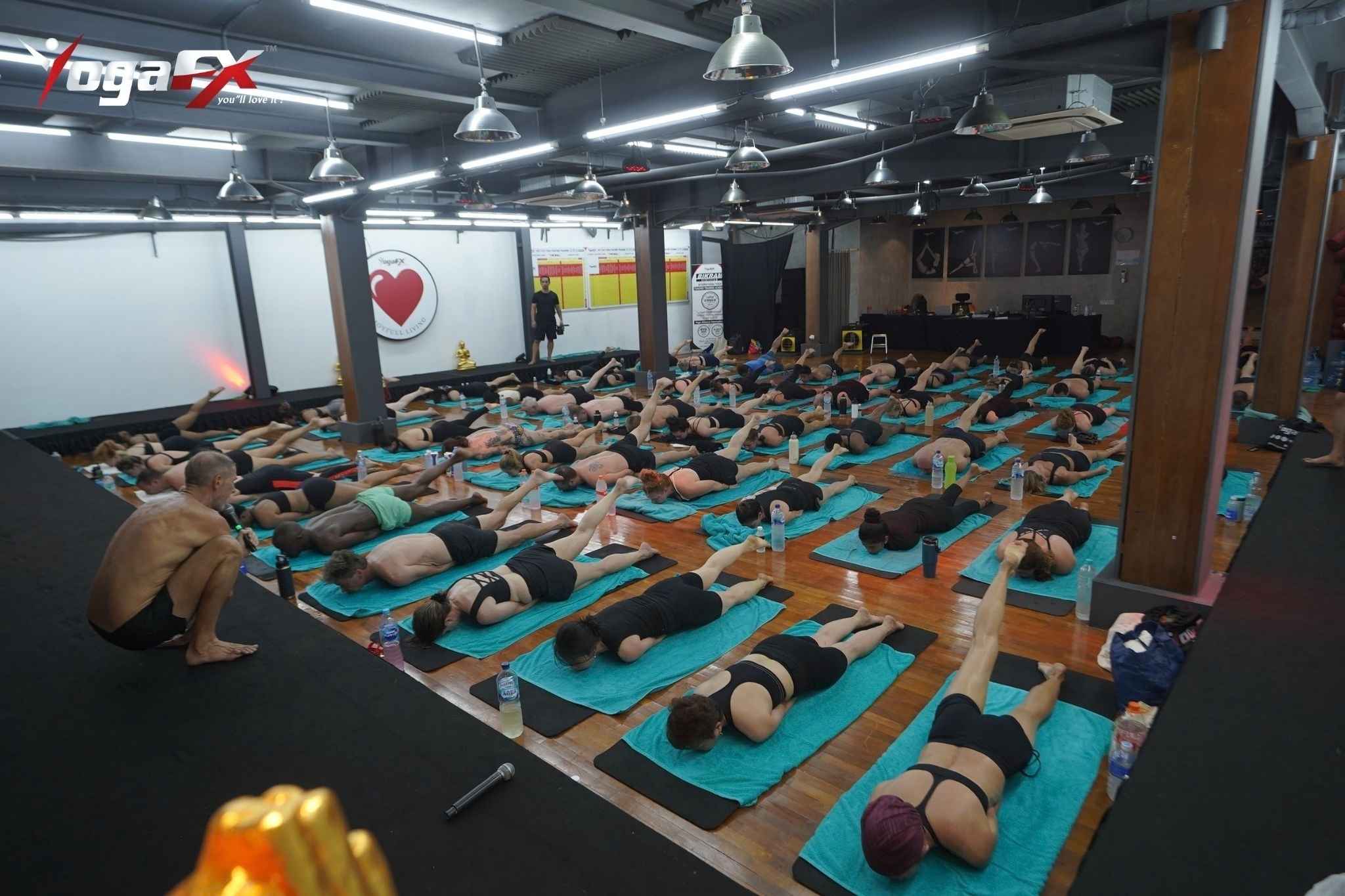 Students resting in Savasana between floor postures during a Bikram Hot 26 and 2 class in natural tropical heat in Bali