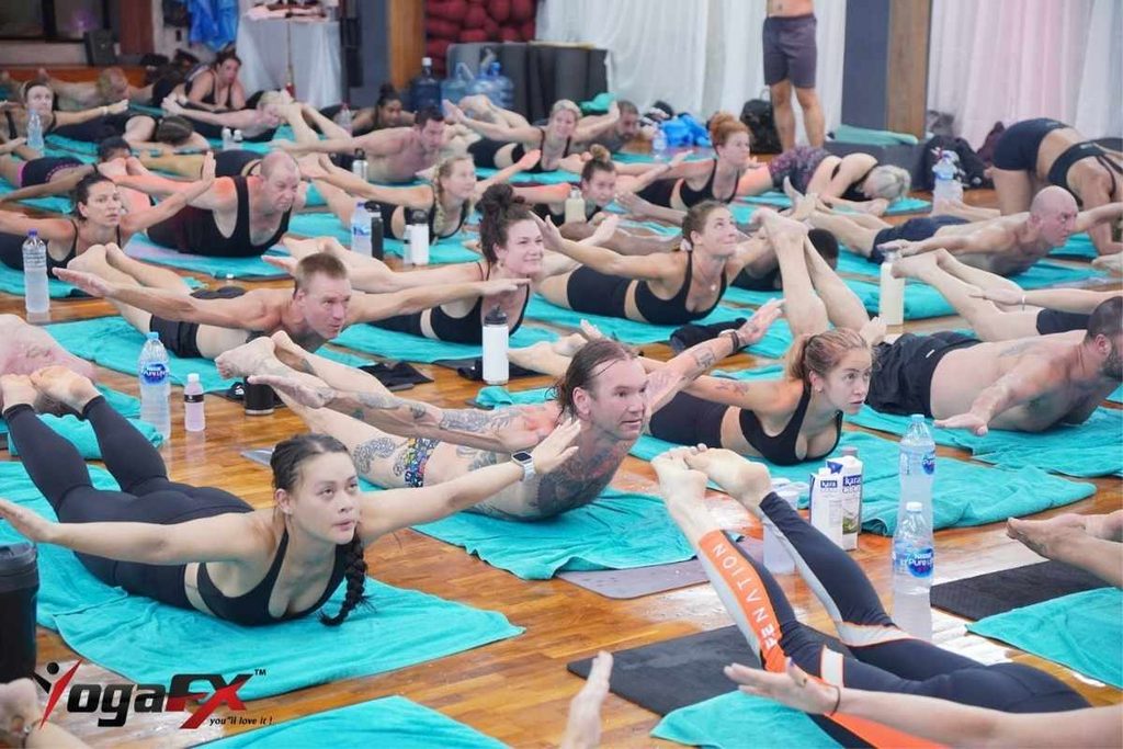 Bikram yoga students moving through the 26 and 2 posture sequence in a heated studio in Seminyak Bali, showing the structured 90 minute hot yoga class format